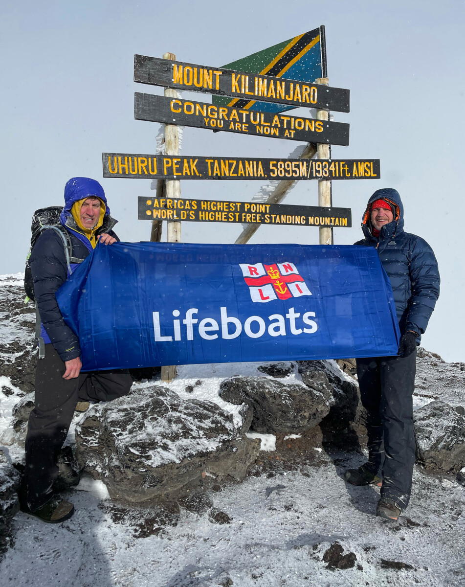 Mountaineers Andy and Darren ‘flying the flag for Exmouth RNLI’ atop Mount Kilimanjaro